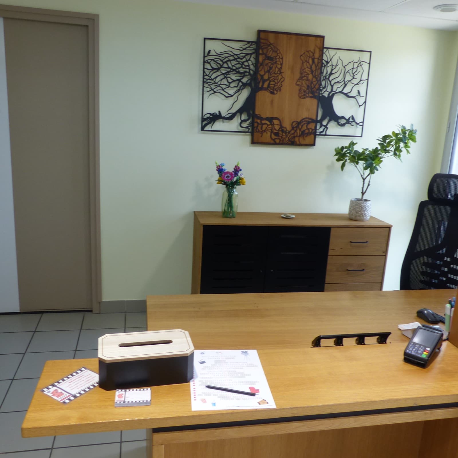 Accueil du cabinet avec bureau en bois et décoration chaleureuse