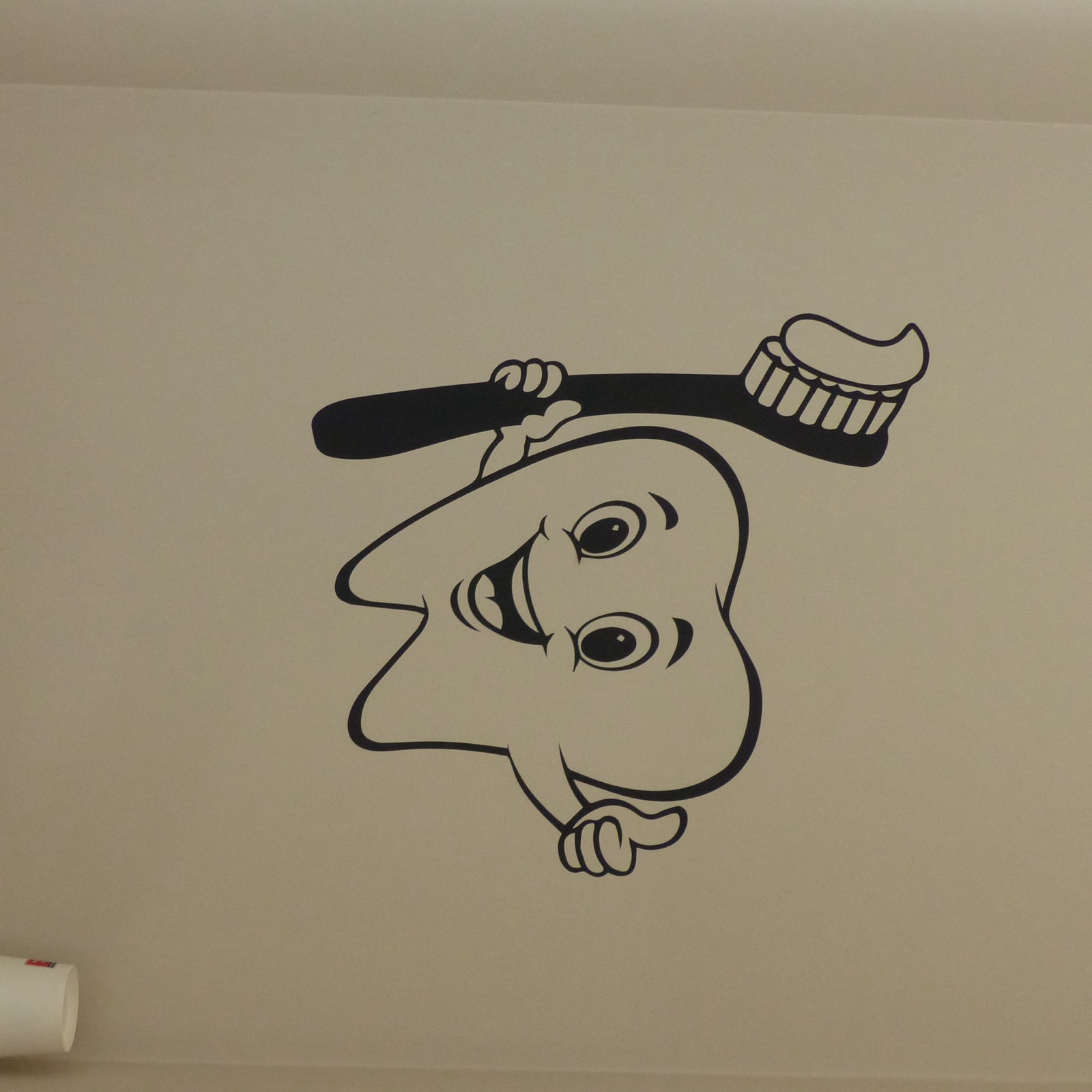 Sticker mural illustrant une dent souriante tenant une brosse à dents
