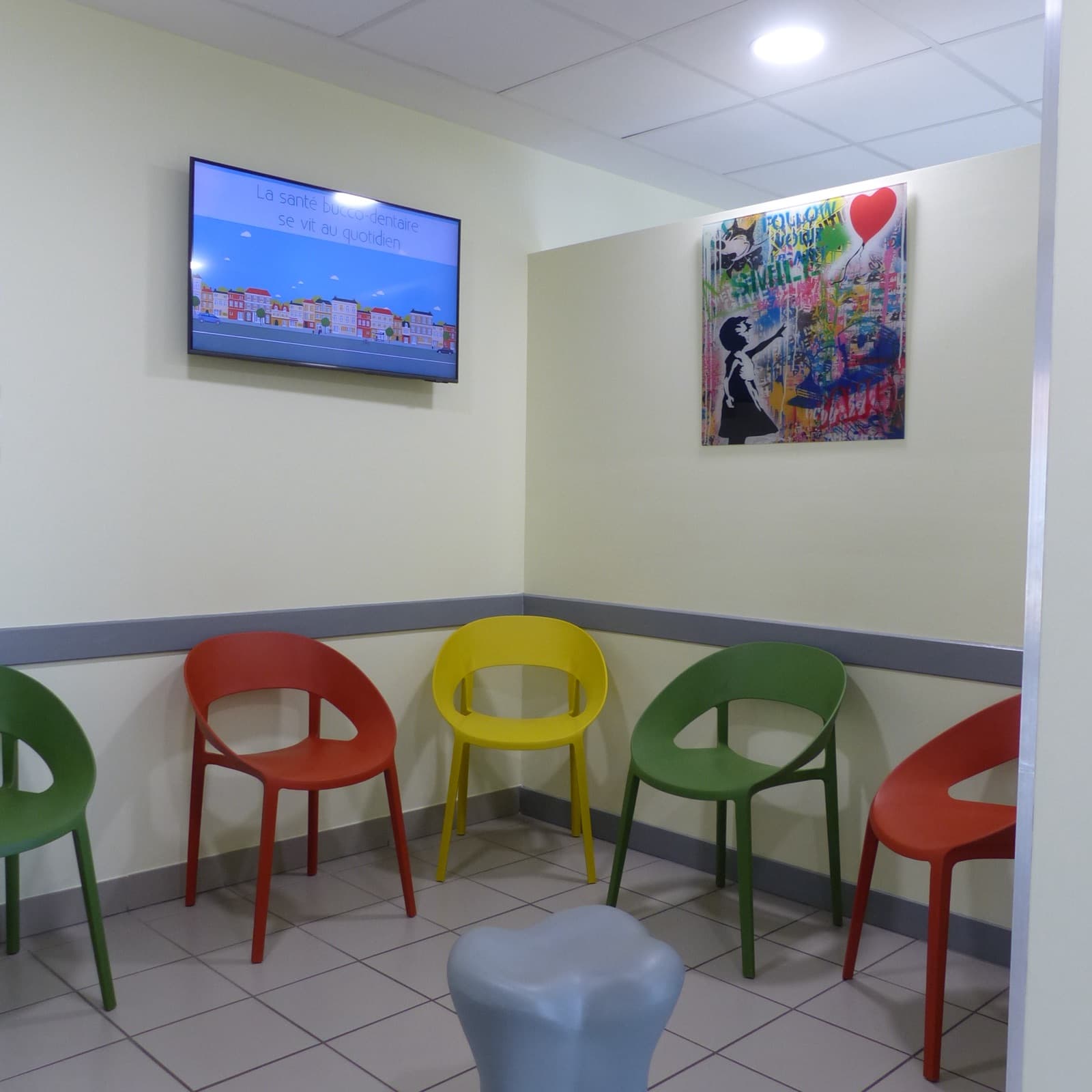 Salle d'attente colorée avec chaises vertes, rouges et jaunes