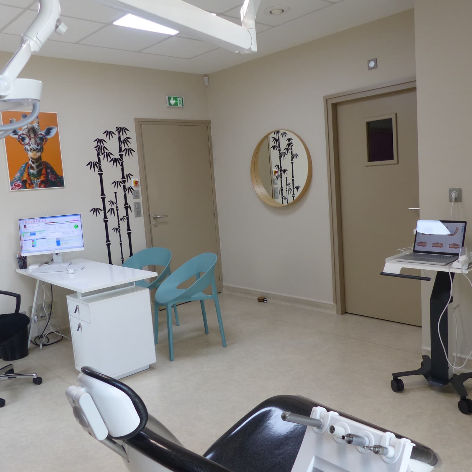 Salle de soin avec fauteuil, scanner intrabuccal, chaises turquoise et affiche girafe